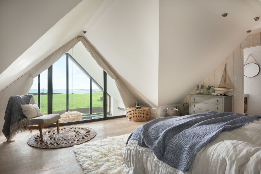 Photo of a beach style bedroom in Cornwall with white walls, light hardwood floors and beige floor.