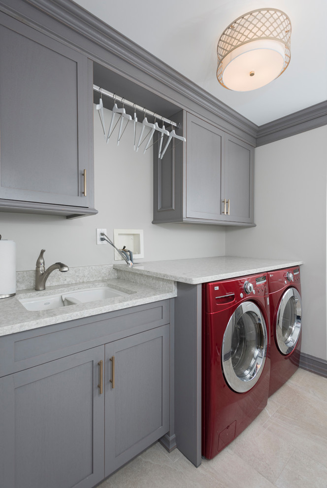 Mid-sized modern single-wall laundry cupboard in New York with a double-bowl sink, recessed-panel cabinets, white cabinets, granite benchtops, beige walls, laminate floors, a side-by-side washer and dryer, grey floor and white benchtop.