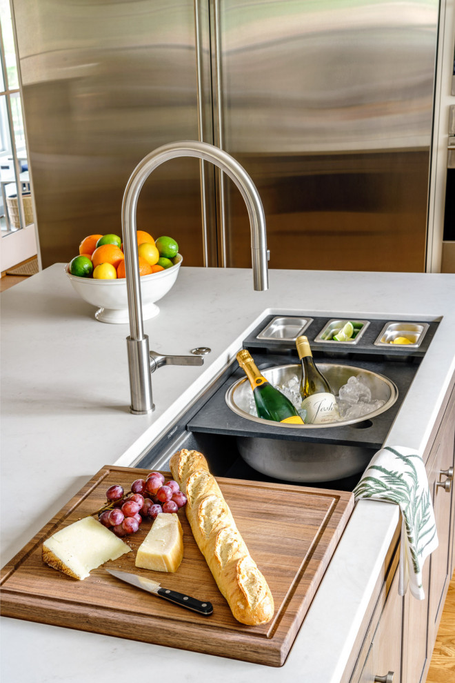 Large transitional galley medium tone wood floor and brown floor eat-in kitchen photo with an undermount sink, shaker cabinets, white cabinets, quartz countertops, white backsplash, marble backsplash, stainless steel appliances, an island and white countertops