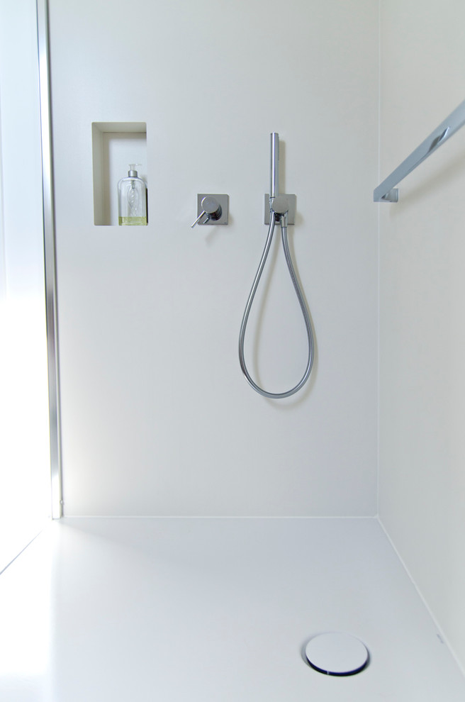 This is an example of a small modern shower room bathroom in Bremen with flat-panel cabinets, grey cabinets, a built-in shower, a two-piece toilet, multi-coloured tiles, ceramic tiles, grey walls, ceramic flooring, an integrated sink and stainless steel worktops.