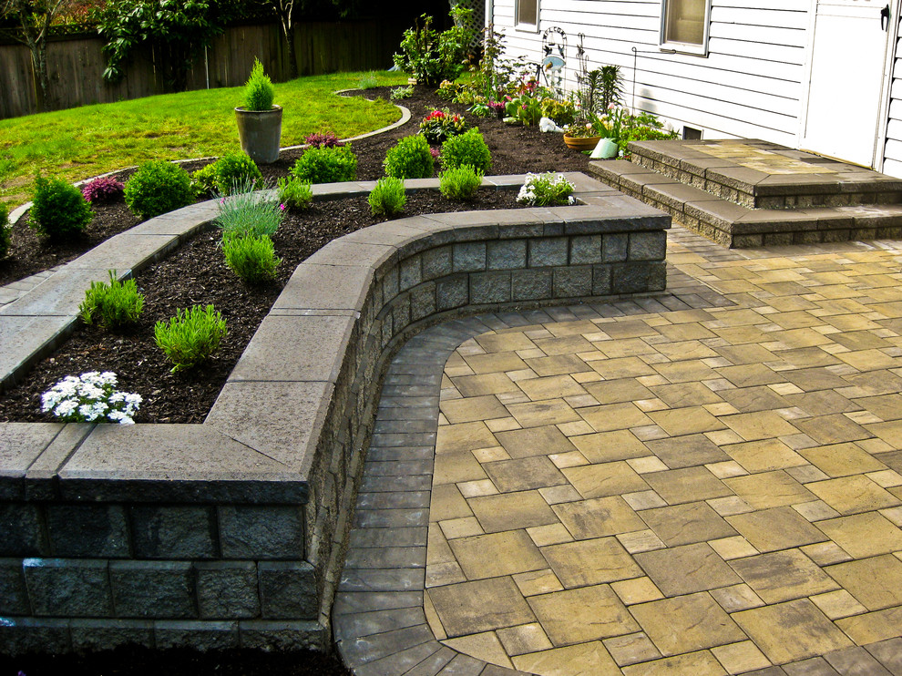 Design ideas for a mid-sized traditional backyard patio in Seattle with natural stone pavers and no cover.