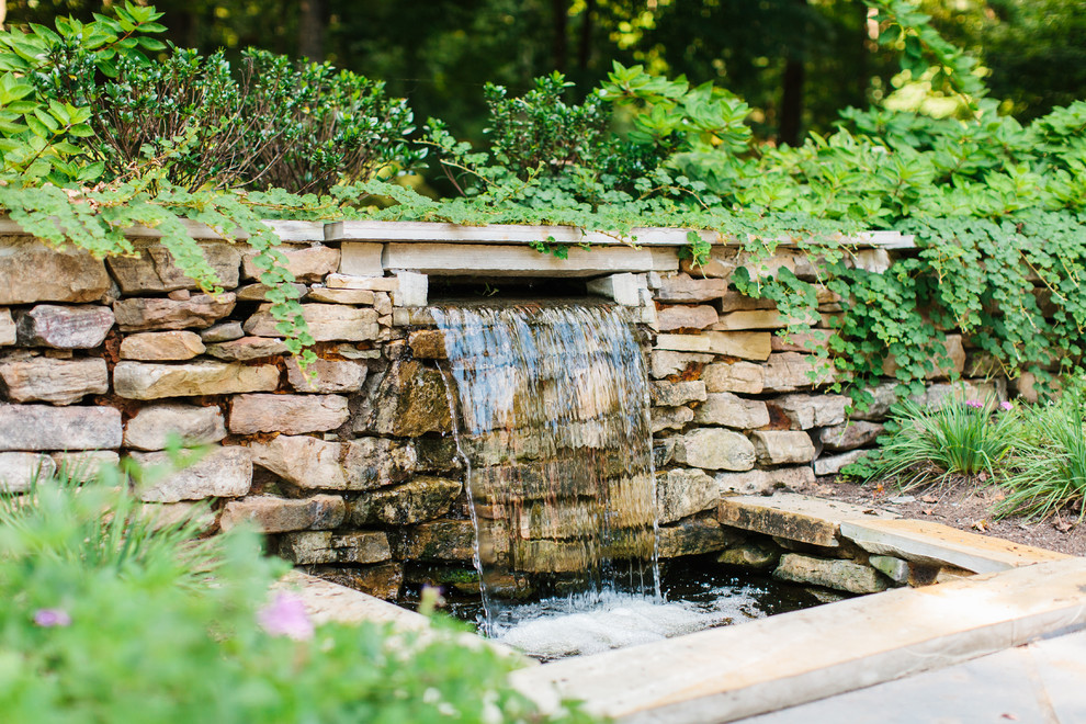 Inspiration for a traditional garden in Other with a water feature.