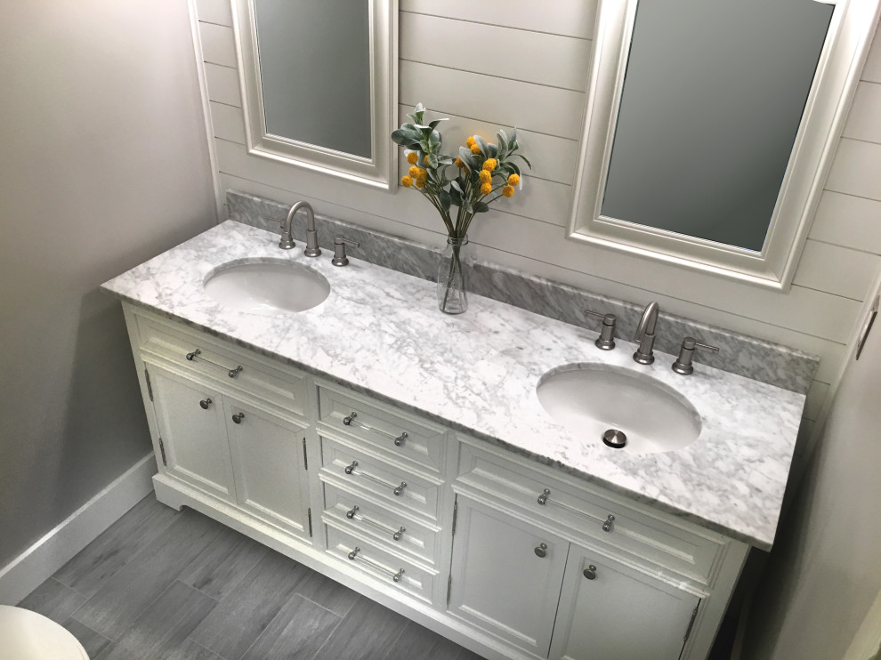 Photo of a small transitional master bathroom in Atlanta with recessed-panel cabinets, white cabinets, a corner shower, a two-piece toilet, yellow tile, ceramic tile, grey walls, porcelain floors, an undermount sink, marble benchtops, grey floor, a hinged shower door and white benchtops.