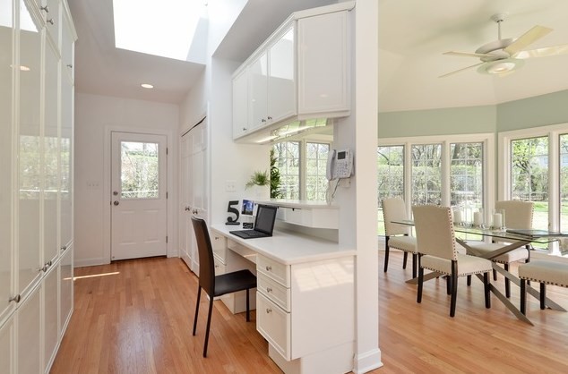 Transitional light wood floor eat-in kitchen photo in Chicago with white cabinets, shaker cabinets, stainless steel appliances and an island