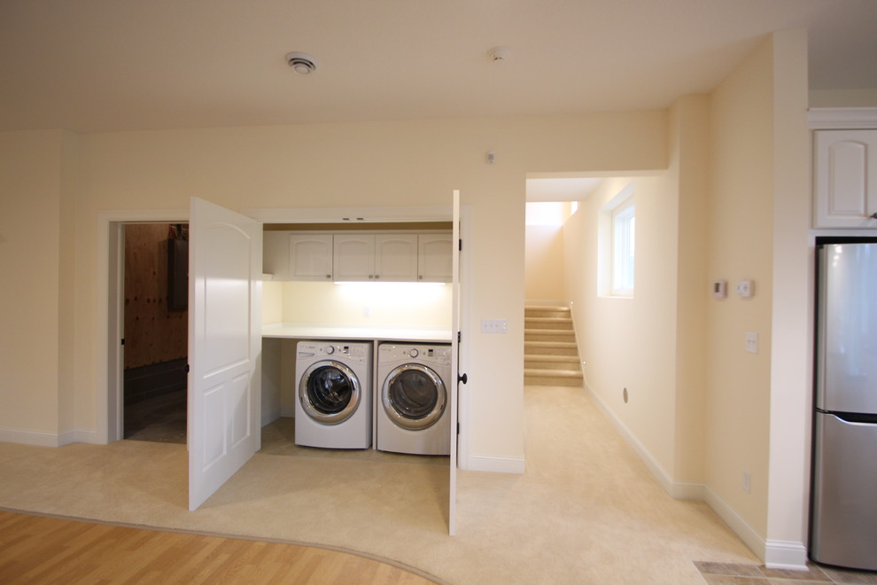 Small traditional single-wall laundry room in Minneapolis with laminate benchtops, beige walls, a side-by-side washer and dryer and carpet.