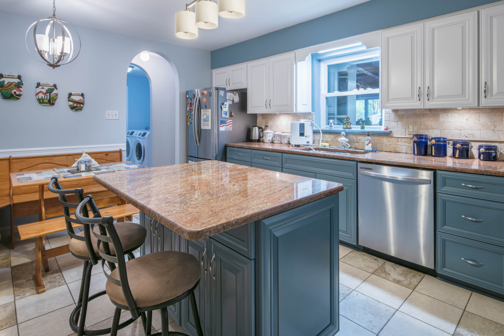 Mid-sized transitional l-shaped ceramic tile and beige floor enclosed kitchen photo in Baltimore with an undermount sink, recessed-panel cabinets, blue cabinets, granite countertops, beige backsplash, stone tile backsplash, stainless steel appliances, an island and orange countertops