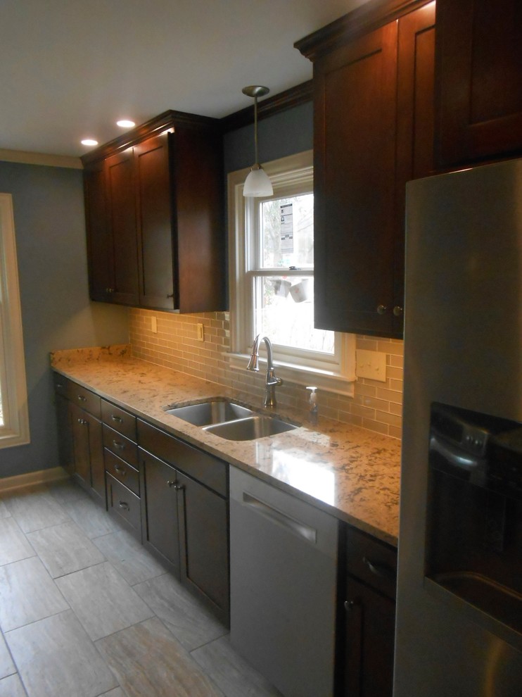 Inspiration for a mid-sized transitional galley porcelain tile eat-in kitchen remodel with an undermount sink, shaker cabinets, dark wood cabinets, quartz countertops, beige backsplash, glass sheet backsplash, stainless steel appliances, blue walls and no island