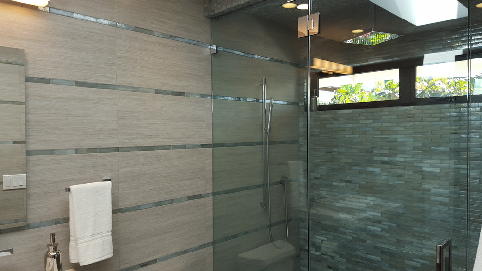 Mid-sized tropical bathroom in Other with an alcove shower, a two-piece toilet, beige tile, gray tile, porcelain tile, beige walls and a vessel sink.
