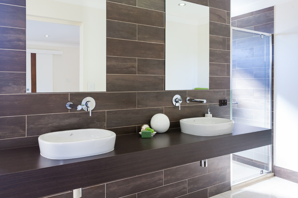 Large contemporary bathroom in Brisbane with a vessel sink, dark wood cabinets and marble floors.