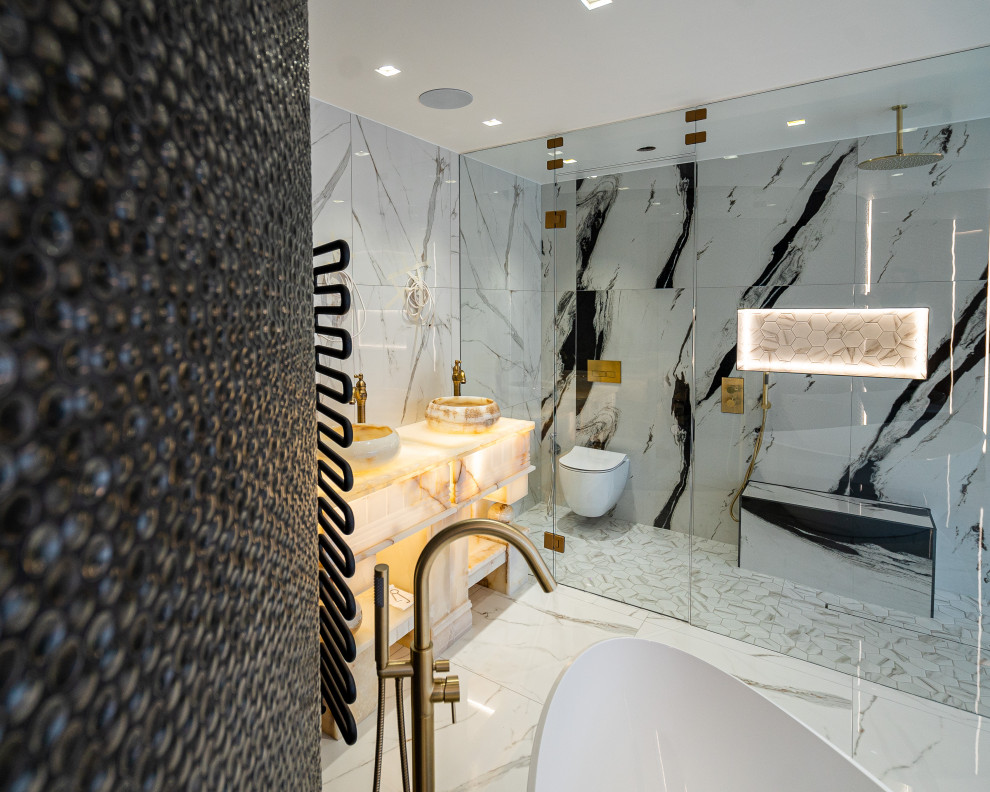 Стильный дизайн: главная ванная комната среднего размера в стиле модернизм с белыми фасадами, отдельно стоящей ванной, двойным душем, унитазом-моноблоком, черной плиткой, белыми стенами, мраморным полом, мраморной столешницей, белым полом, душем с распашными дверями, белой столешницей, нишей, тумбой под две раковины, напольной тумбой и многоуровневым потолком - последний тренд