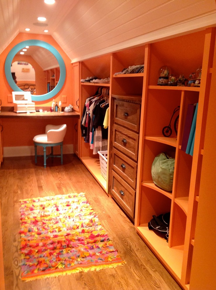 Design ideas for a mid-sized eclectic gender-neutral dressing room in New York with shaker cabinets, medium wood cabinets and medium hardwood floors.