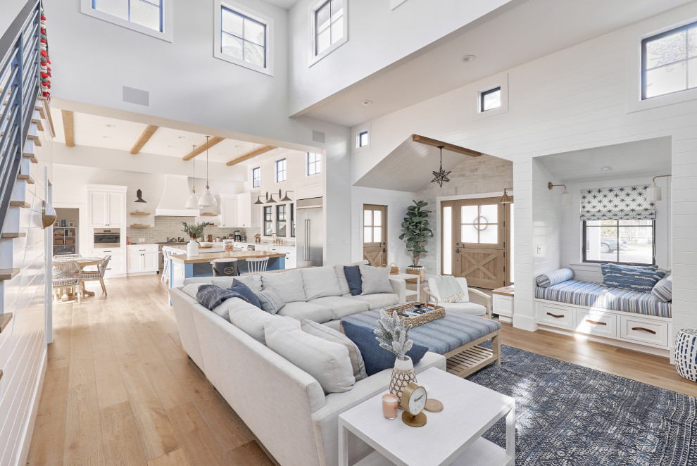 Inspiration for a large country mezzanine living room in Orange County with a reading nook, white walls, light hardwood flooring, a standard fireplace, a brick fireplace surround, a wall mounted tv, beige floors, exposed beams and tongue and groove walls.
