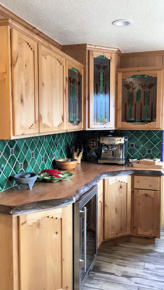 Example of a small mountain style u-shaped porcelain tile enclosed kitchen design in Phoenix with an undermount sink, shaker cabinets, light wood cabinets, wood countertops, green backsplash, stainless steel appliances and an island