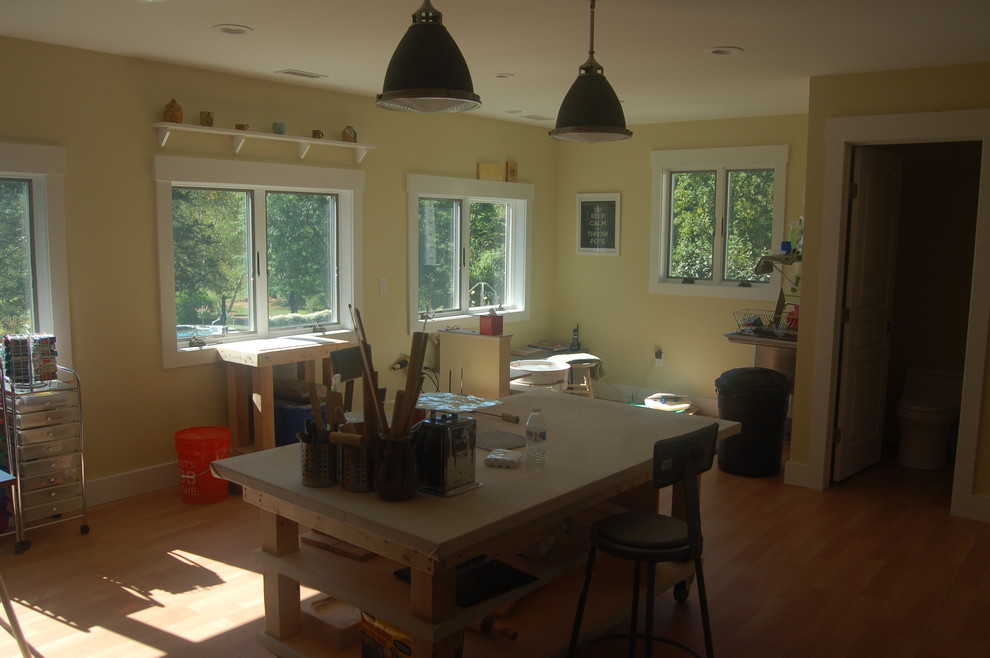 Photo of a mid-sized contemporary home studio in New York with a freestanding desk, yellow walls and medium hardwood floors.