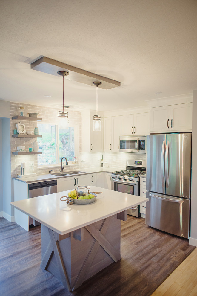 Open concept kitchen - mid-sized transitional l-shaped open concept kitchen idea in Vancouver with an undermount sink, shaker cabinets, white cabinets, quartz countertops, gray backsplash, stainless steel appliances and an island