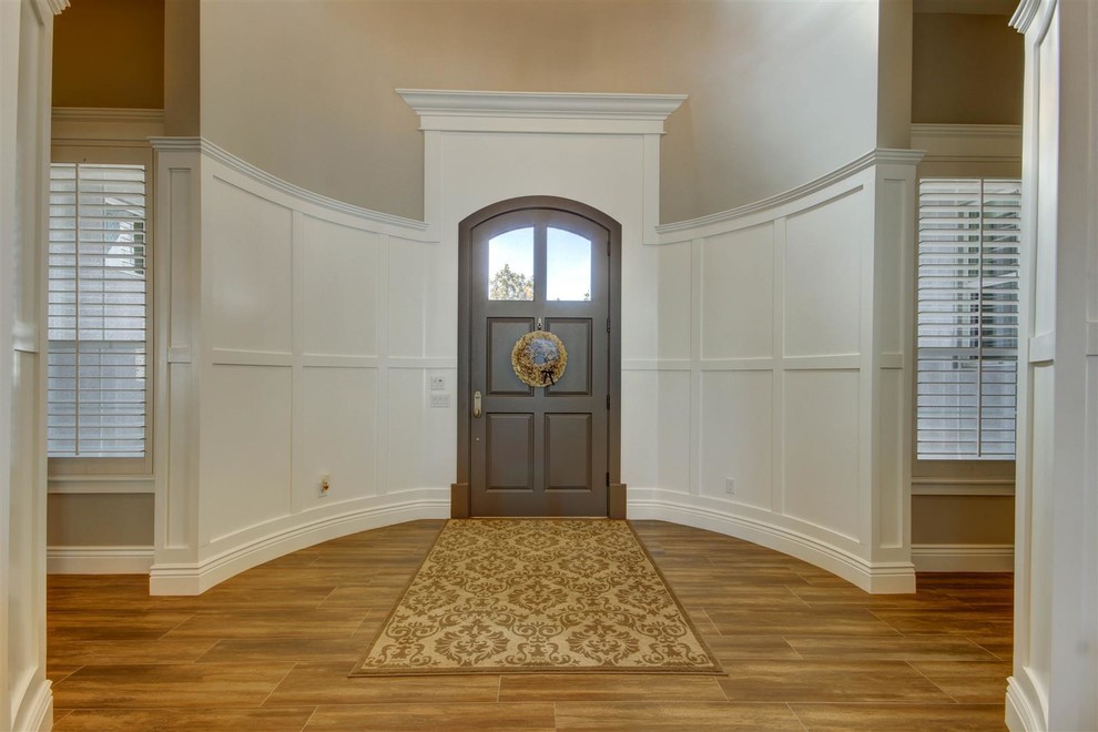 Example of a large transitional medium tone wood floor foyer design in Phoenix with gray walls and a brown front door
