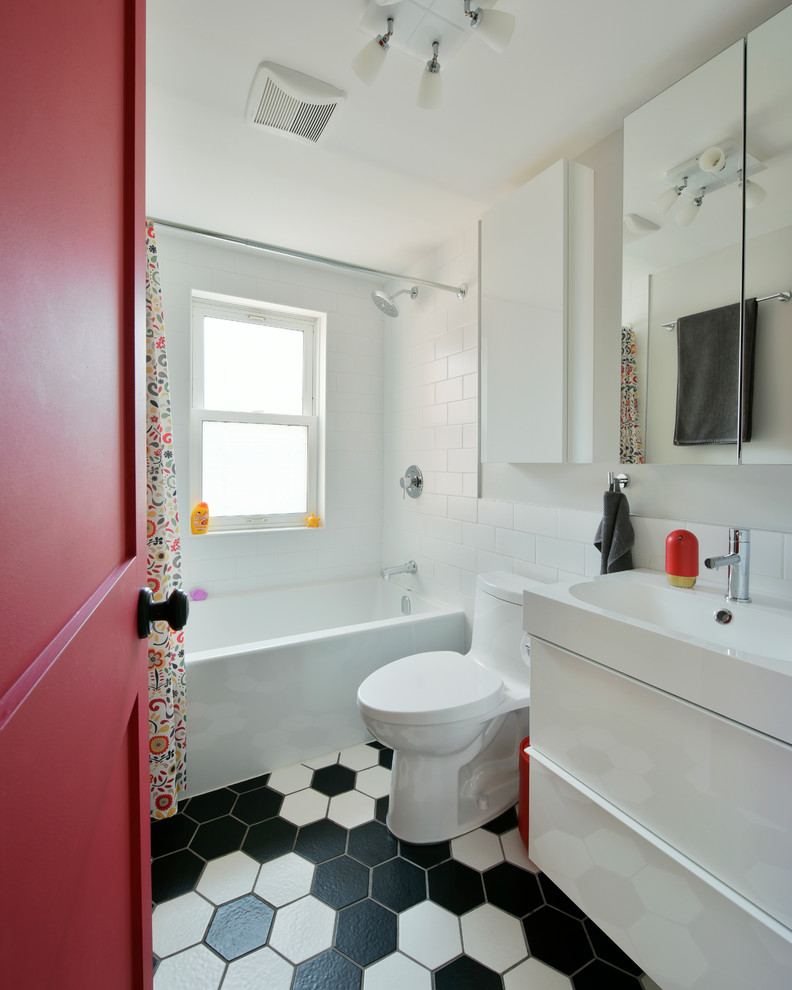 Photo of a mid-sized eclectic kids bathroom in Ottawa with flat-panel cabinets, white cabinets, a shower/bathtub combo, a one-piece toilet, ceramic tile, white walls, porcelain floors, an integrated sink and solid surface benchtops.