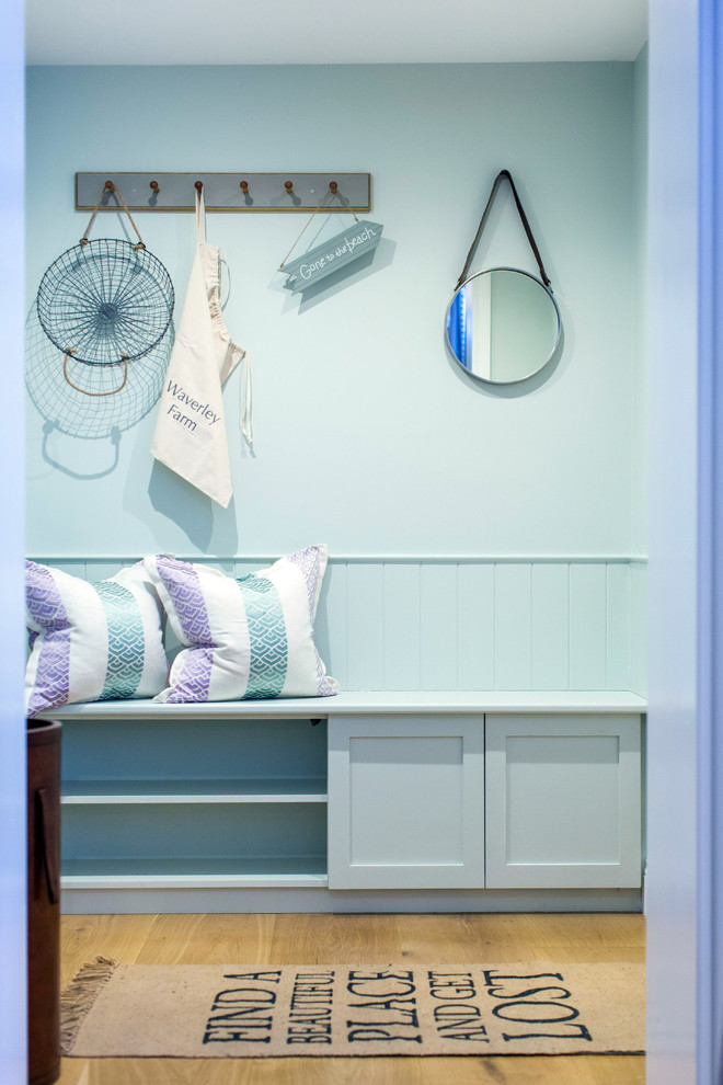 Photo of a coastal boot room in Buckinghamshire with blue walls, light hardwood flooring and a dado rail.