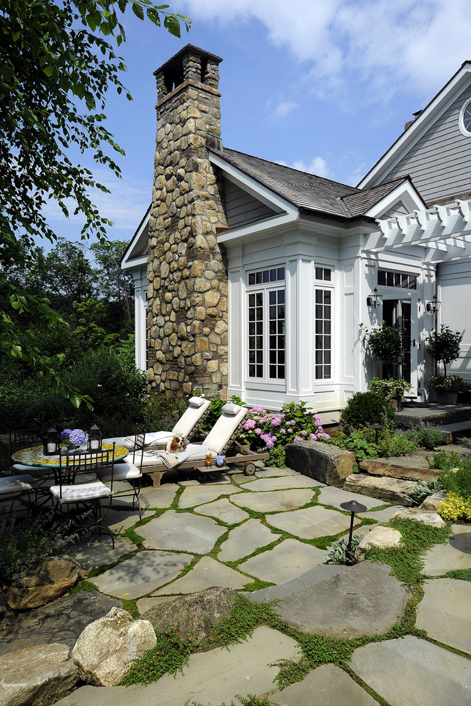 Inspiration for a traditional backyard patio in New York with natural stone pavers and no cover.