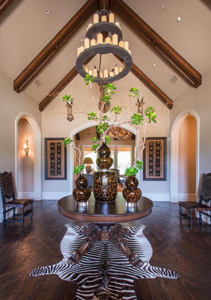 Example of a large mountain style dark wood floor and brown floor foyer design in Dallas with beige walls and a dark wood front door