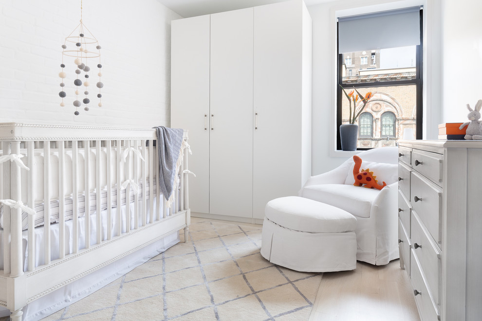 Inspiration for a mid-sized contemporary nursery for boys in New York with grey walls, light hardwood floors and beige floor.