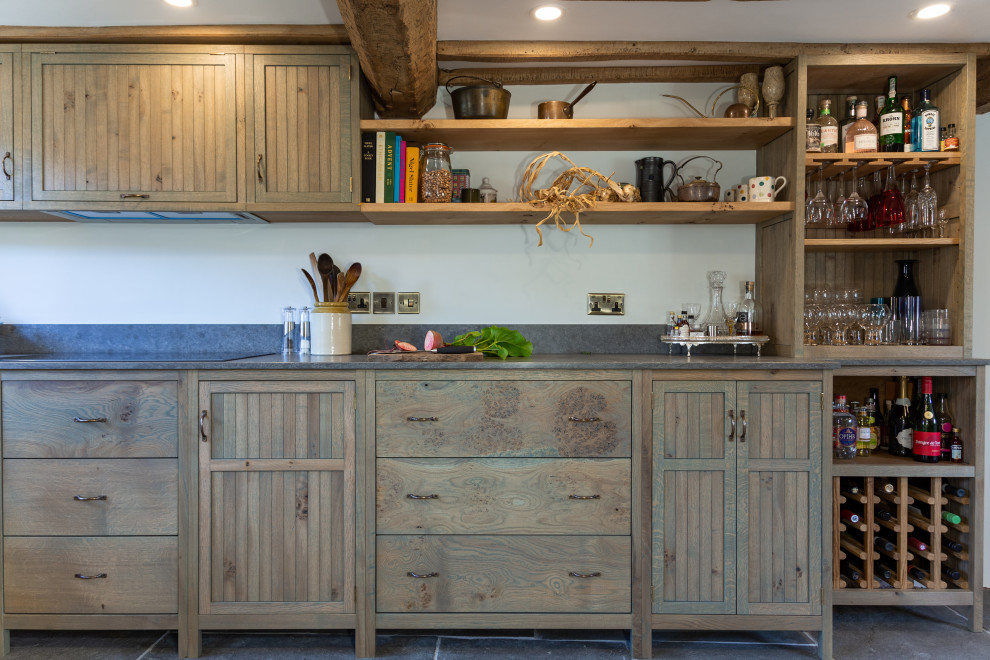 Inspiration for a mid-sized country galley eat-in kitchen in West Midlands with a farmhouse sink, shaker cabinets, green cabinets, quartzite benchtops, grey splashback, engineered quartz splashback, panelled appliances, slate floors, no island, grey floor, grey benchtop and exposed beam.