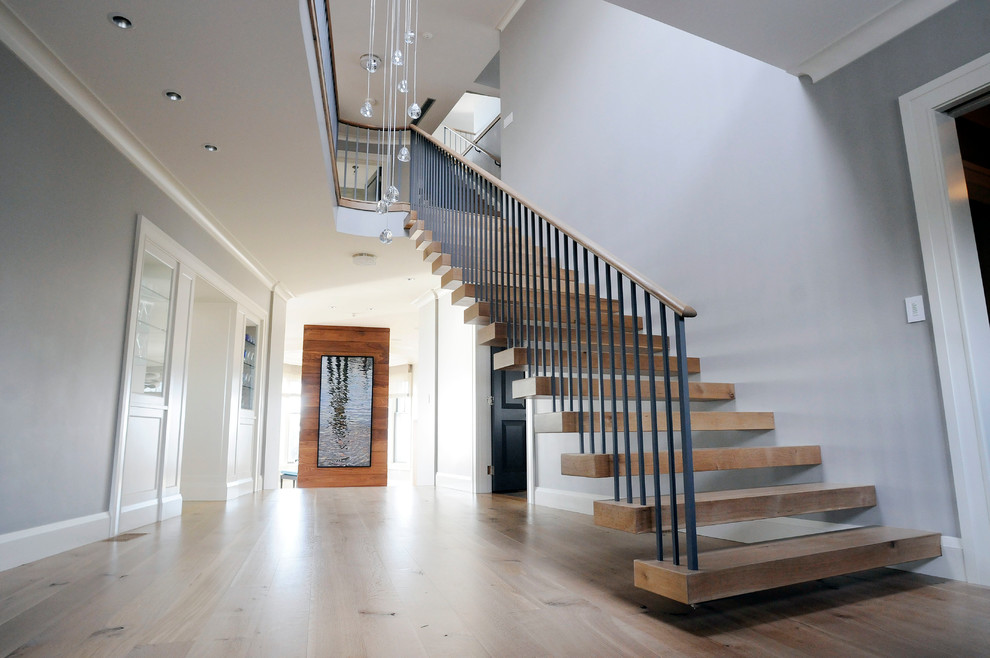 Photo of a large contemporary wood floating staircase in Boston with open risers.