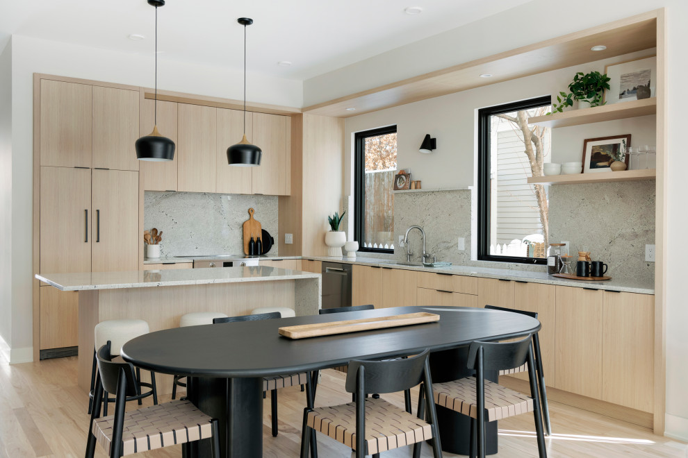 Example of a danish l-shaped light wood floor and beige floor kitchen design in Minneapolis with an undermount sink, flat-panel cabinets, light wood cabinets, gray backsplash, stone slab backsplash, stainless steel appliances, an island and gray countertops