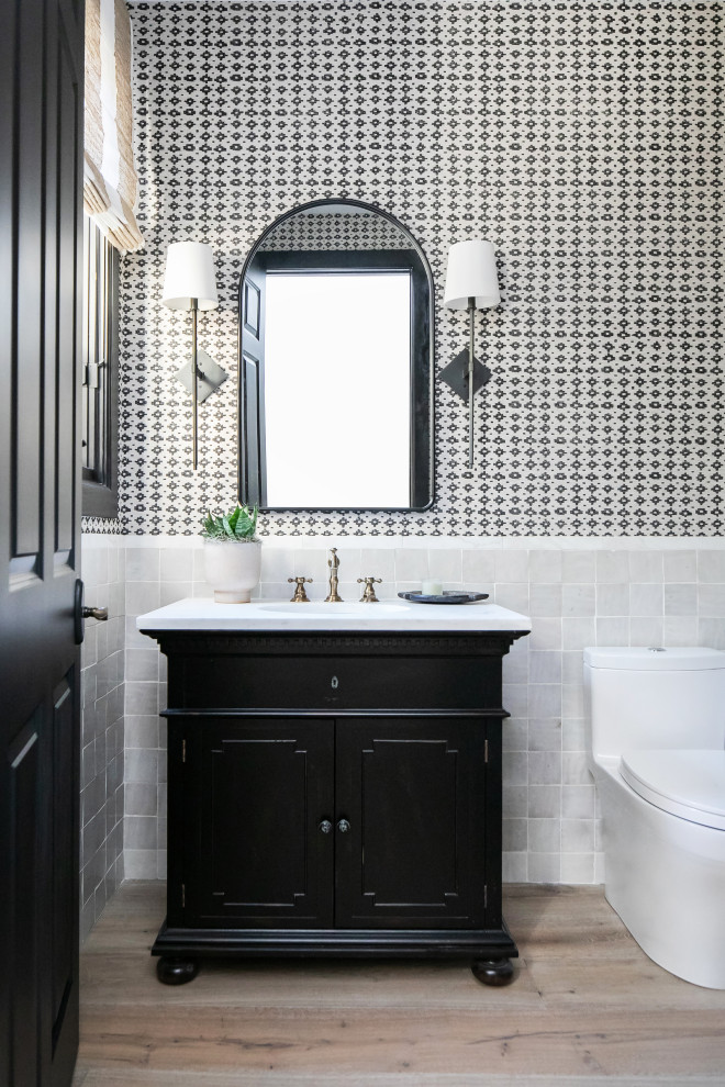 Inspiration for a traditional cloakroom in San Diego with freestanding cabinets, black cabinets, a one-piece toilet, white tiles, ceramic tiles, multi-coloured walls, medium hardwood flooring, a freestanding vanity unit and wallpapered walls.