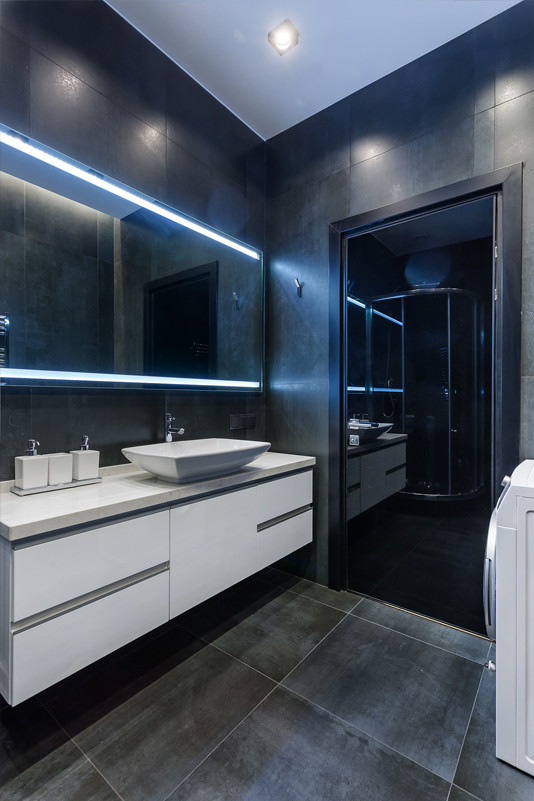 Design ideas for a small contemporary 3/4 bathroom in Moscow with flat-panel cabinets, white cabinets, a corner shower, a wall-mount toilet, black tile, porcelain tile, black walls, porcelain floors, a vessel sink, engineered quartz benchtops, black floor, a sliding shower screen and white benchtops.