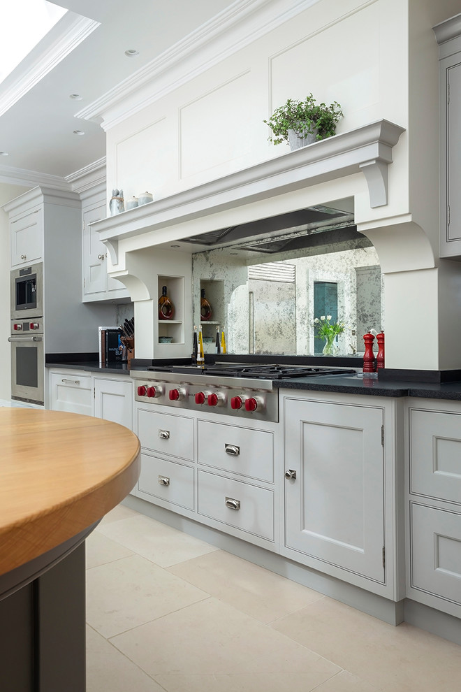 Inspiration for a large traditional kitchen/diner in Surrey with flat-panel cabinets, grey cabinets, marble worktops, limestone flooring, an island and beige floors.