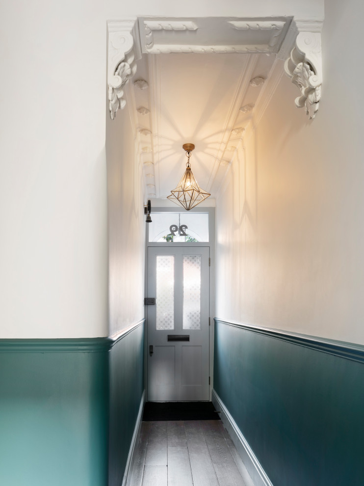 Photo of a mid-sized traditional entry hall in London with green walls, dark hardwood floors, a single front door, a gray front door and brown floor.