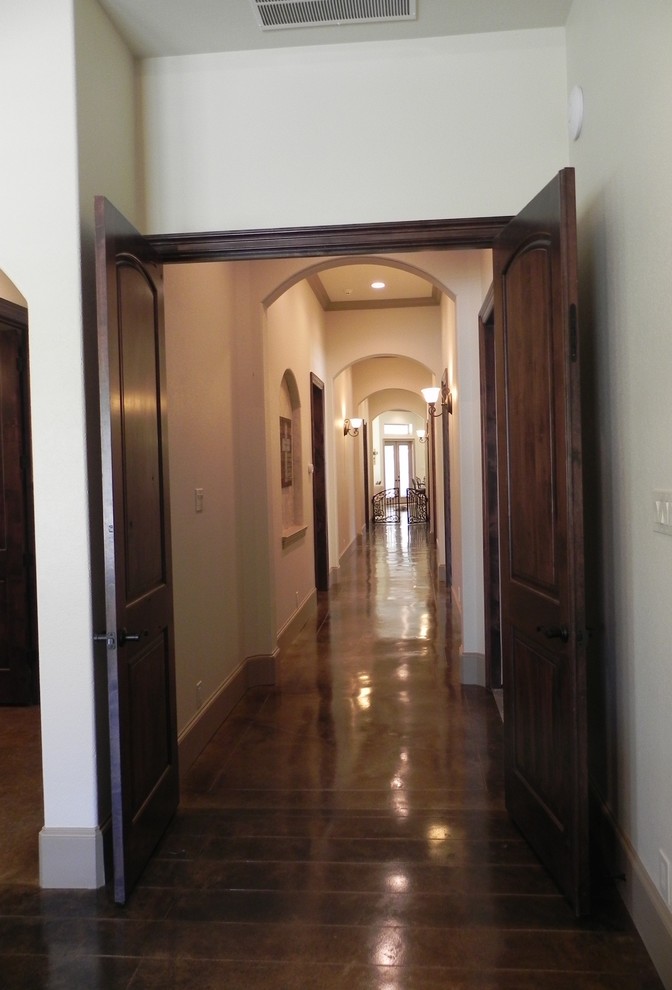 Inspiration for an expansive country hallway in Houston with beige walls and concrete floors.