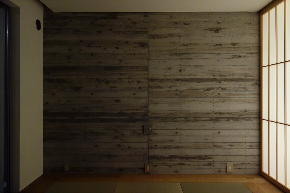 Exemple d'une chambre parentale asiatique avec un mur gris et un sol en bois brun.