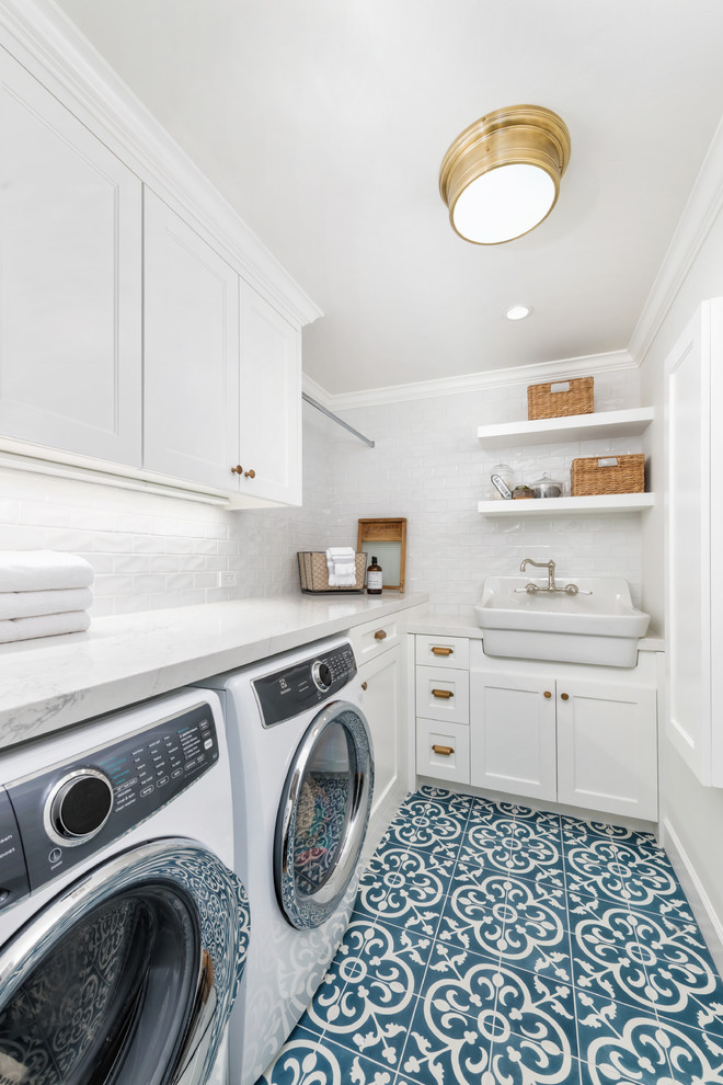 Inspiration for a small country l-shaped ceramic tile and blue floor dedicated laundry room remodel in San Francisco with a farmhouse sink, white cabinets, quartz countertops, white walls, a side-by-side washer/dryer, white countertops and shaker cabinets