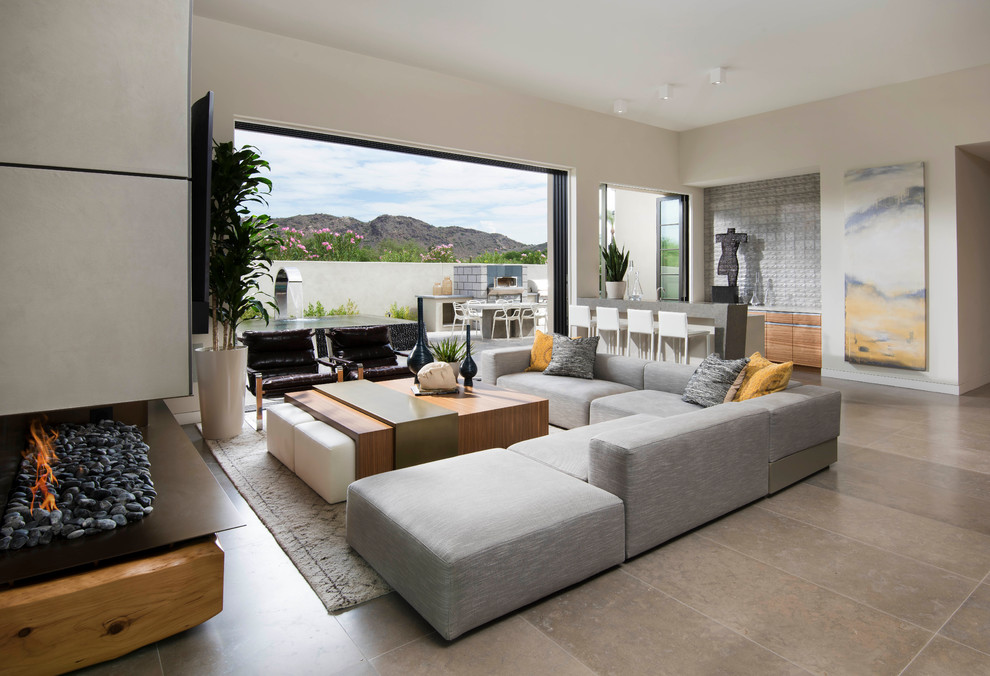 Contemporary open concept living room in Phoenix with limestone floors and a wall-mounted tv.