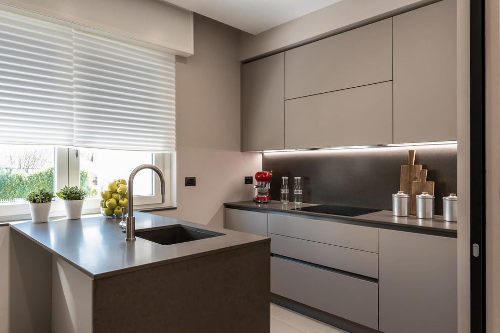 Inspiration for a small contemporary galley kitchen in Milan with an undermount sink, flat-panel cabinets, grey cabinets, grey splashback, stone slab splashback, a peninsula and grey benchtop.