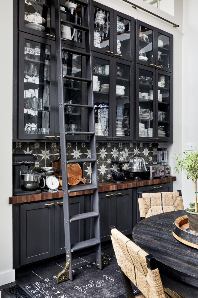 Traditional single-wall home bar in DC Metro with glass-front cabinets, black cabinets, wood benchtops, multi-coloured splashback, cement tile splashback, porcelain floors, grey floor and brown benchtop.