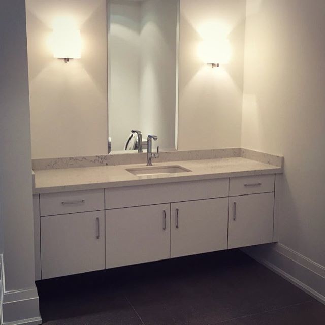 Mid-sized transitional 3/4 ceramic tile bathroom photo in Toronto with flat-panel cabinets, white cabinets, white walls, an undermount sink and marble countertops