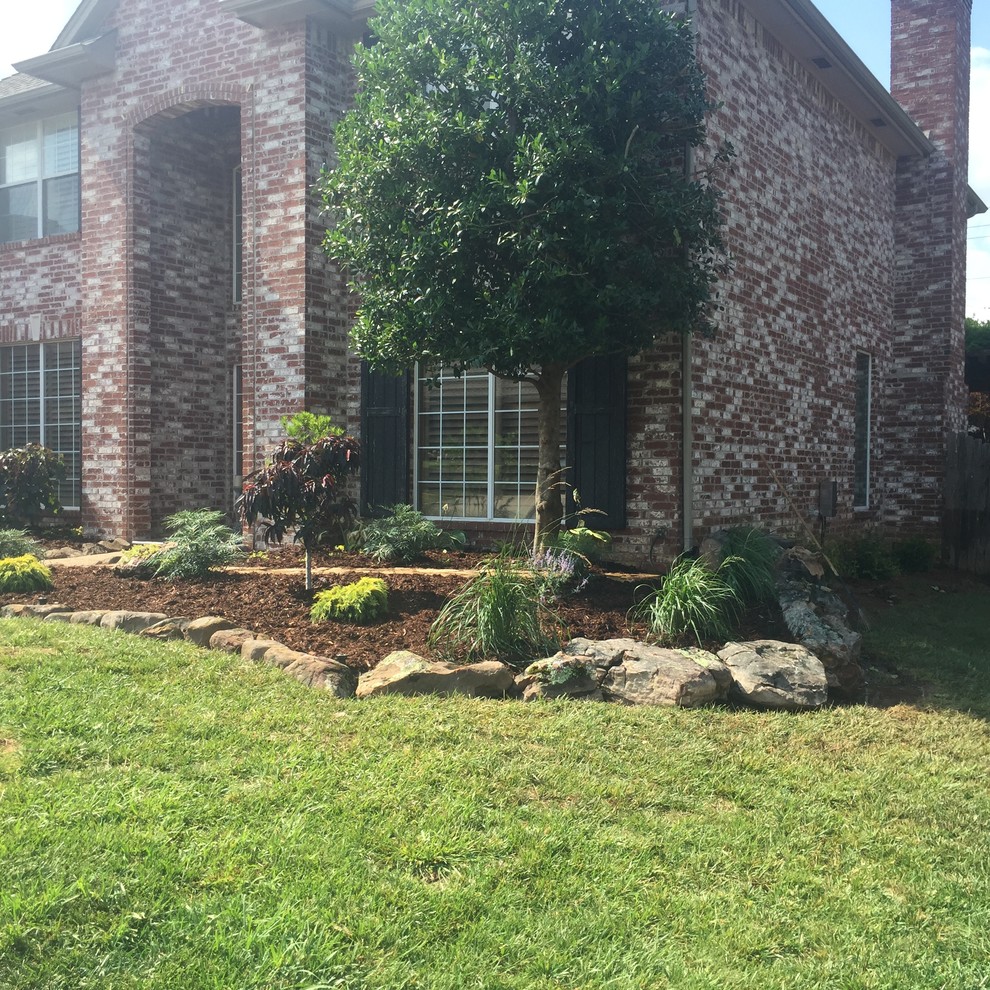 Design ideas for a mid-sized traditional front yard full sun formal garden in Oklahoma City with natural stone pavers.