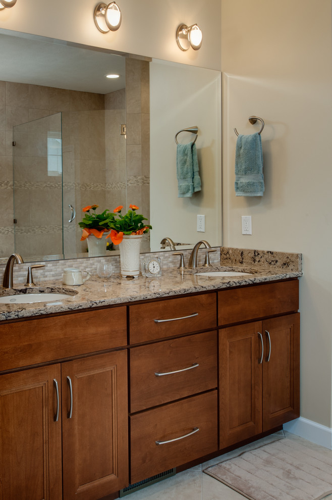 Example of a large transitional master beige tile and stone tile bathroom design with an undermount sink, recessed-panel cabinets, medium tone wood cabinets, granite countertops and beige walls