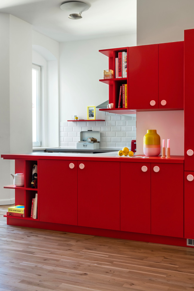 На фото: кухня среднего размера в стиле модернизм с плоскими фасадами, красными фасадами и красной столешницей с