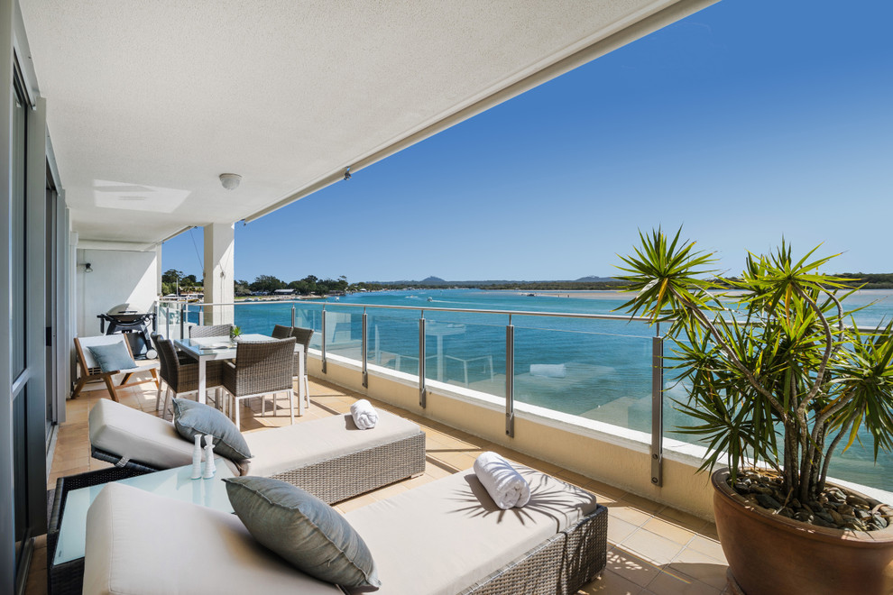 Design ideas for a beach style balcony in Sunshine Coast with a roof extension.