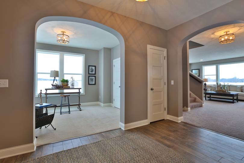 Mid-sized traditional hallway in Minneapolis with beige walls and light hardwood floors.