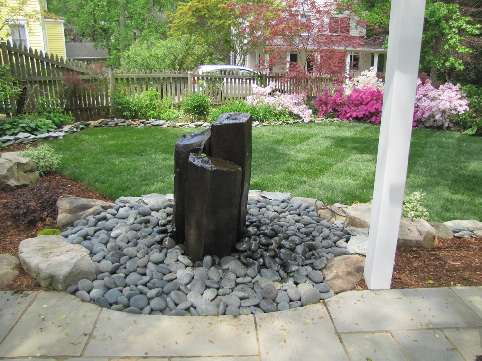 Inspiration for a mid-sized traditional backyard garden in DC Metro with a water feature and concrete pavers.