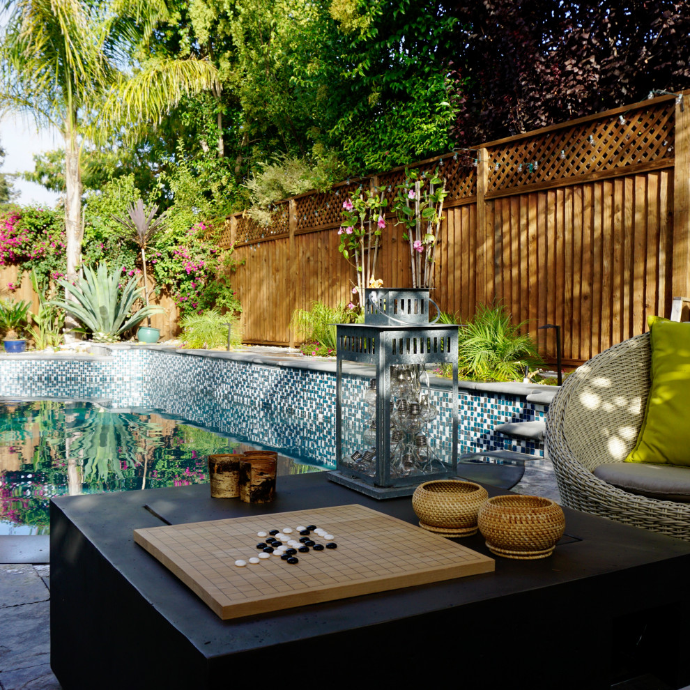 Cette image montre un piscine avec aménagement paysager arrière design de taille moyenne avec des pavés en pierre naturelle.