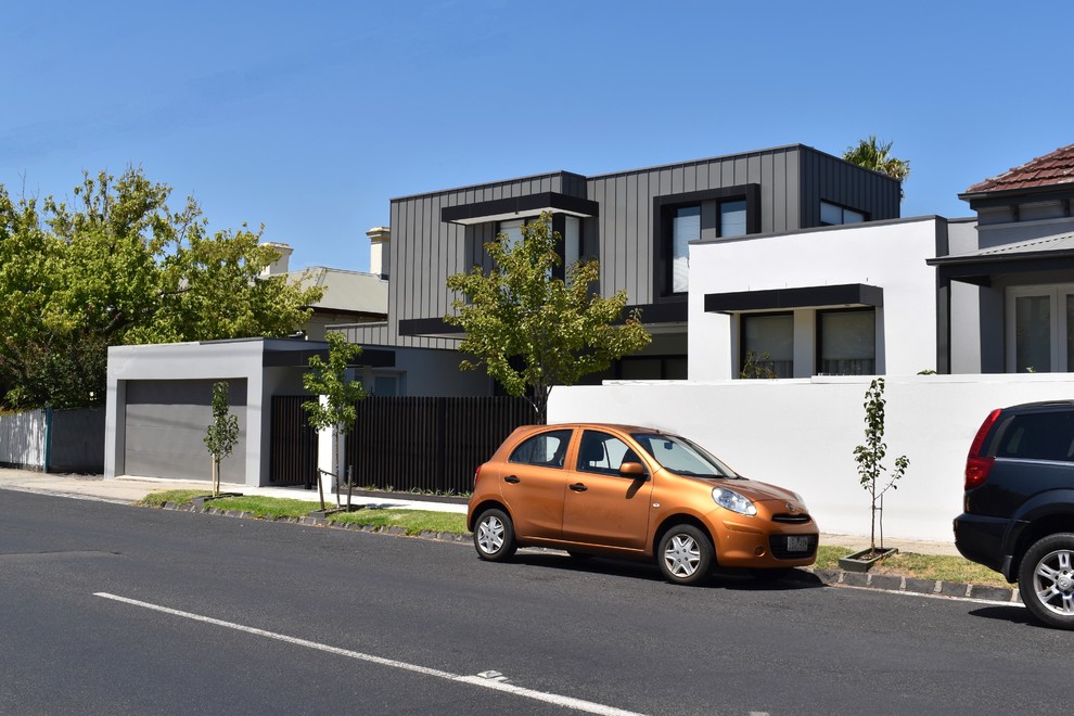 Photo of a mid-sized contemporary two-storey grey townhouse exterior in Melbourne with metal siding, a flat roof and a metal roof.