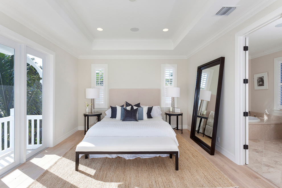 Photo of a transitional bedroom in Miami with beige walls and light hardwood floors.