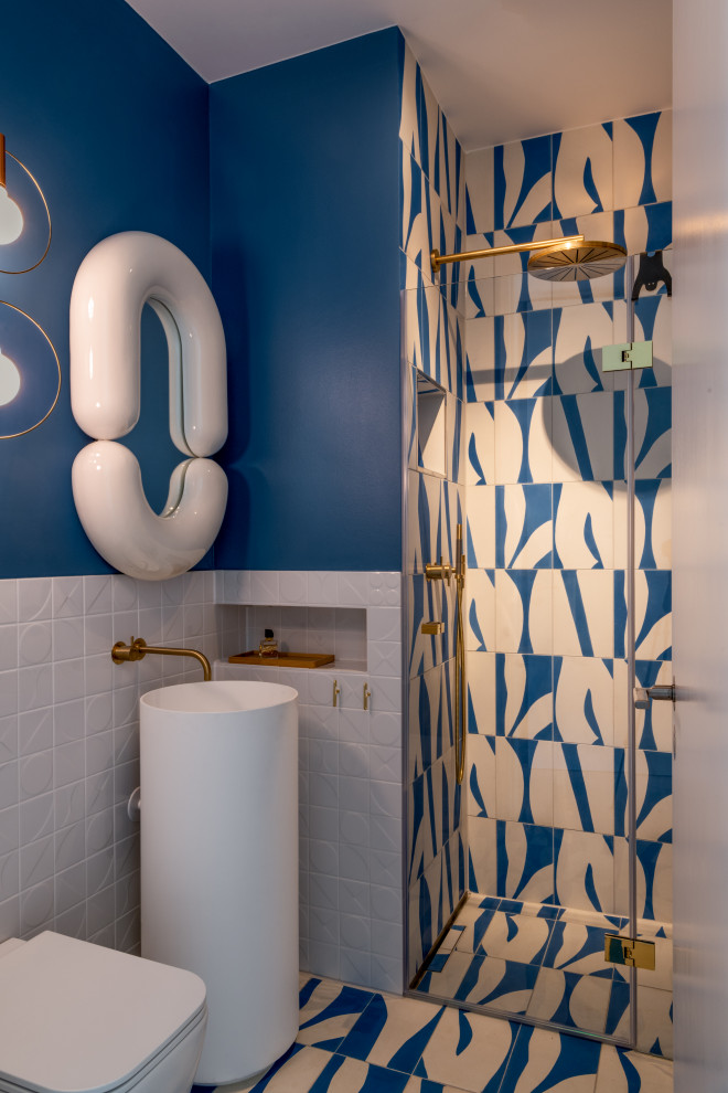 Idéer för ett litet modernt toalett, med en vägghängd toalettstol, blå väggar, cementgolv, bänkskiva i akrylsten och grönt golv