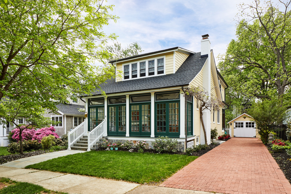 Example of a mid-sized classic yellow two-story concrete fiberboard exterior home design in DC Metro with a shingle roof